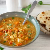 Creamy vegetable and chicken soup topped with fresh herbs.