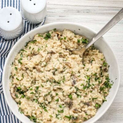 Creamy mushroom risotto with chopped herbs and cheese.