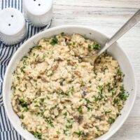 A serving bowl of Instant Pot mushroom risotto garnished with Parmesan cheese.
