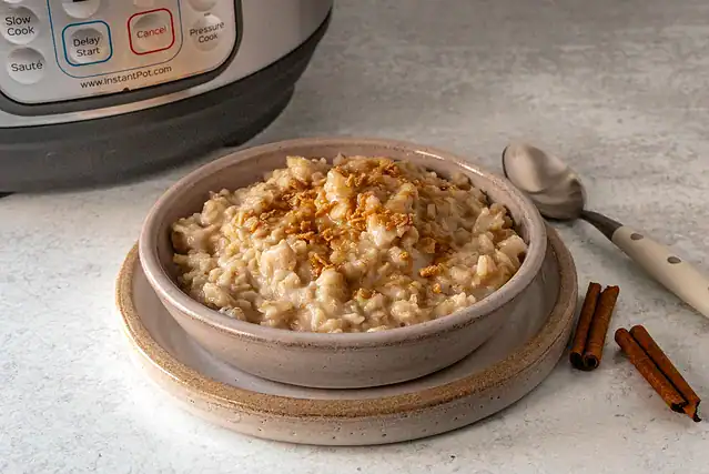 A serving of Instant Pot oatmeal with cinnamon sticks and a sprinkle of maple flakes.