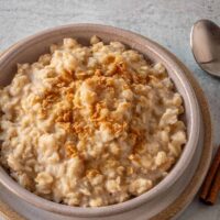 A serving of Instant Pot oatmeal with cinnamon sticks and a sprinkle of maple flakes.