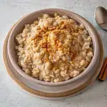Creamy oatmeal topped with a sprinkle of cinnamon and crushed nuts.