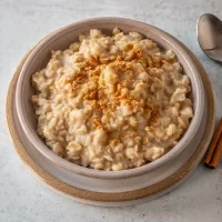 Creamy oatmeal topped with a sprinkle of cinnamon and crushed nuts.