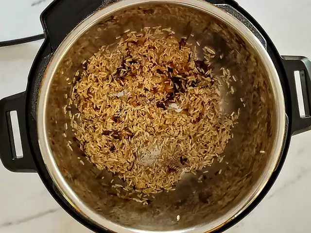 Rice and aromatics in the Instant Pot.