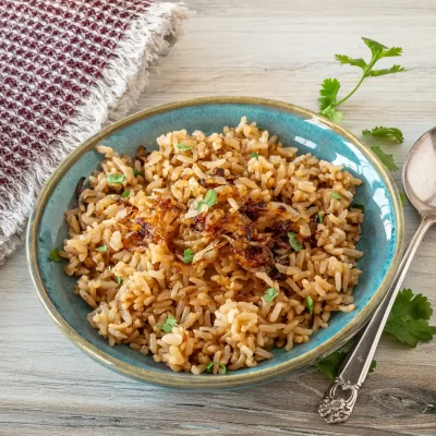 Golden fried rice topped with crispy onions and fresh herbs.