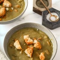 Bowls of Instant Pot pea soup with crunchy croutons, ready to enjoy.