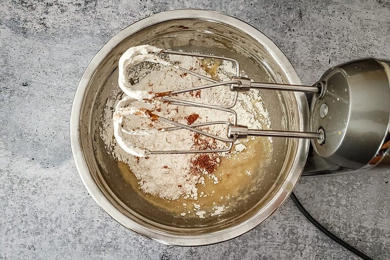 Flour, cocoa, and butter mixture in a mixing bowl with beaters.