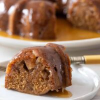 A delicious slice of moist Instant Pot pear cake with the rest of the cake in the background.