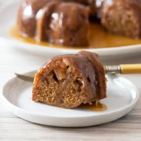 Fried apple dumpling with caramel sauce on a white dish.