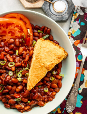 Instant Pot baked pinto beans with cornbread and tomatoes.