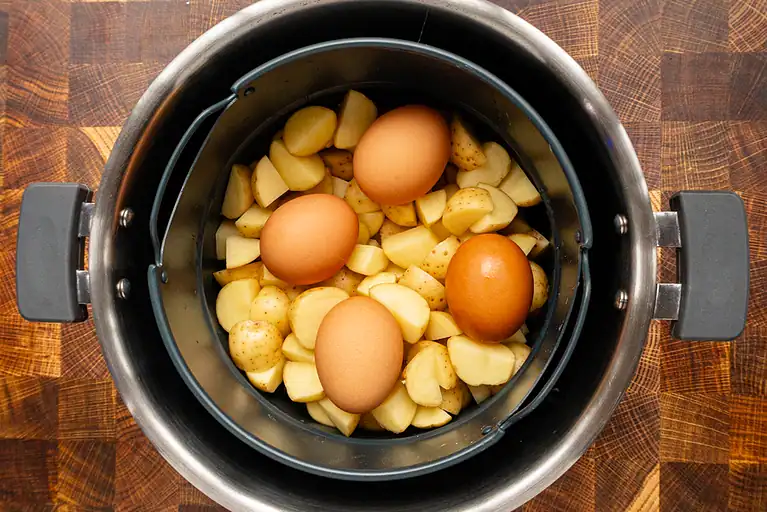 Mixed potatoes and eggs in a slow cooker.