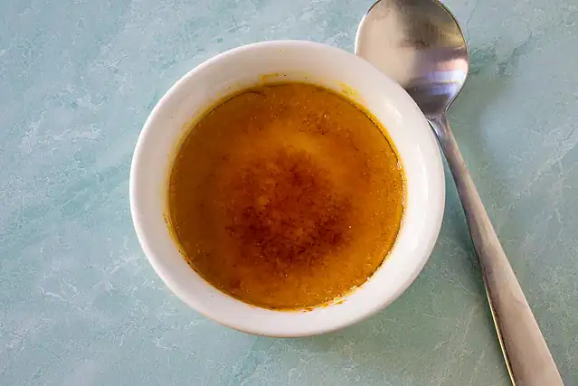 Use a torch to make the sugar crust on the pumpkin crème brûlée desserts.