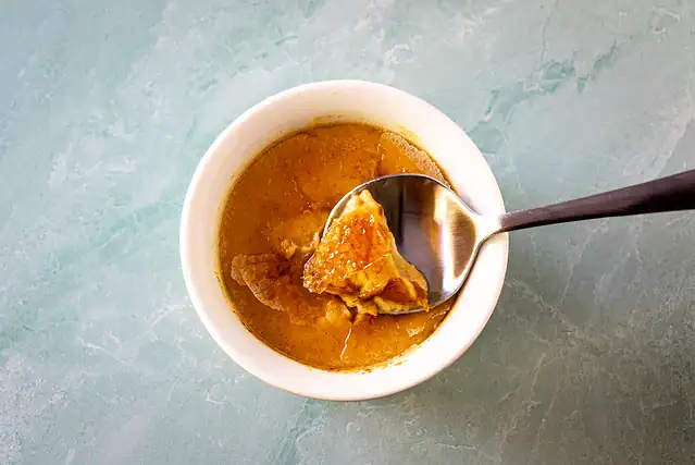 A ramekin with Instant Pot pumpkin crème brûlée showing the crisp sugar crust.