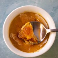 A ramekin with Instant Pot pumpkin crème brûlée showing the crisp sugar crust.