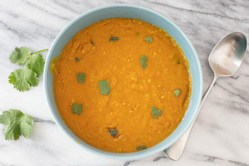 A bowl of Instant Pot red lentil dal with cilantro garnish