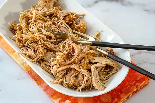 Instant Pot shredded chicken on a plate with forks.