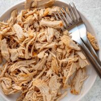 Instant Pot shredded chicken on a plate with forks.