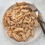 Instant Pot shredded chicken on a plate with forks.