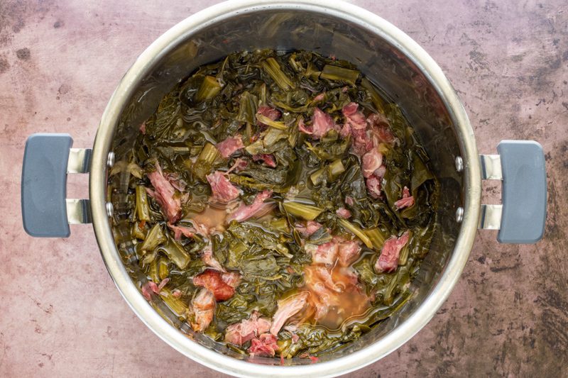 Add the shredded ham hock meat back to the instant pot greens