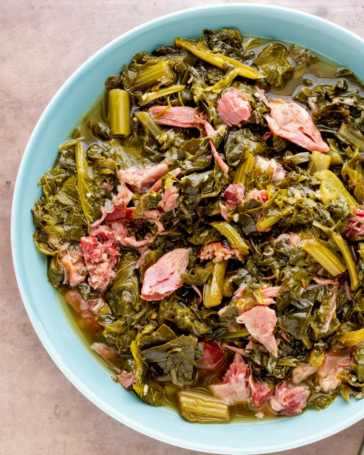Boiled greens with pieces of ham in a light broth.