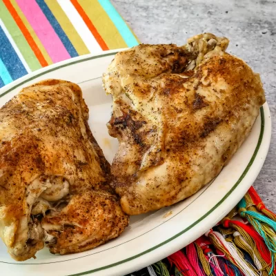 Golden-brown roasted chicken thighs on a white plate.