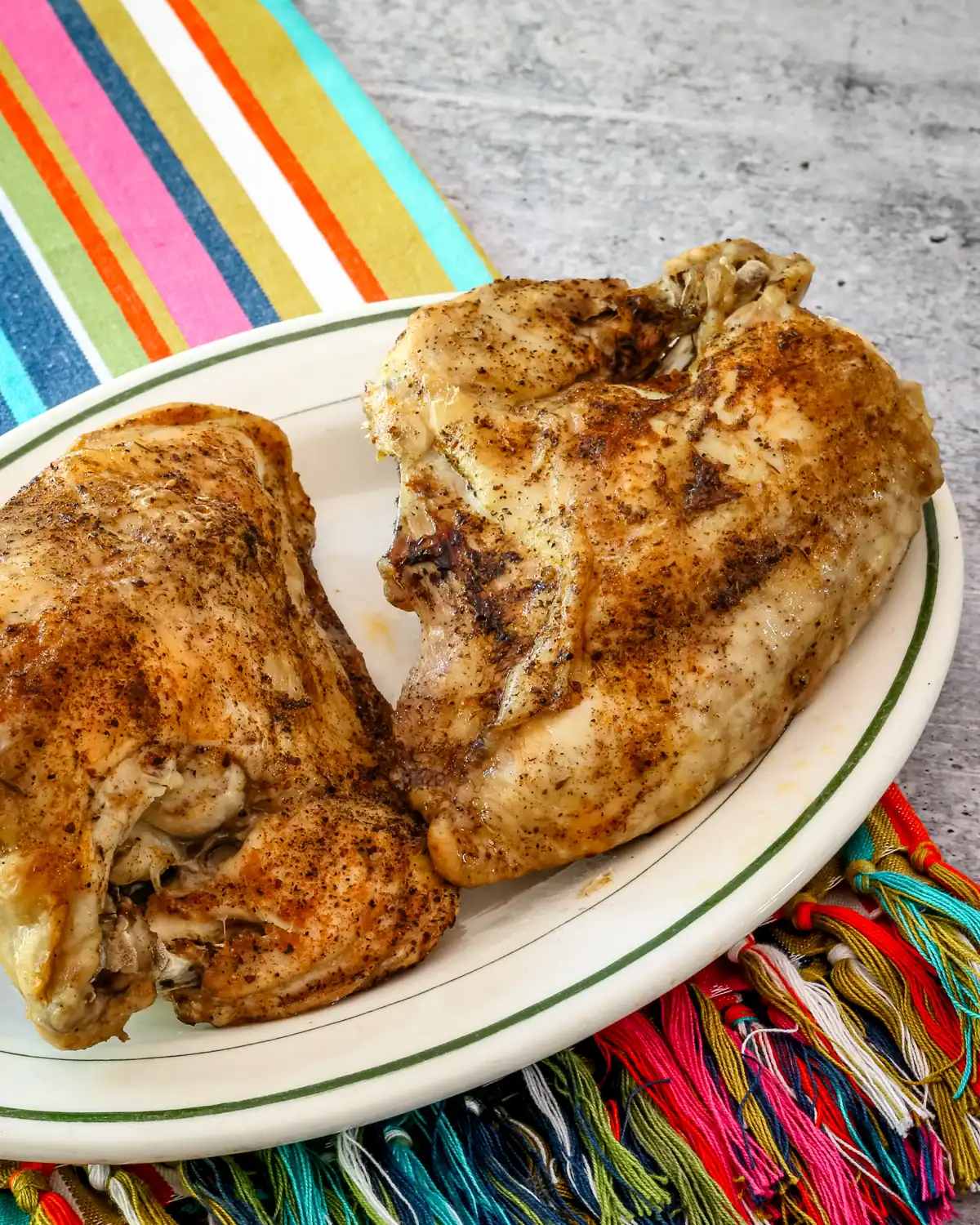 Golden-brown roasted chicken thighs on a white plate.