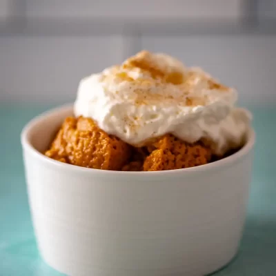 Sweet potato casserole topped with whipped cream and cinnamon.