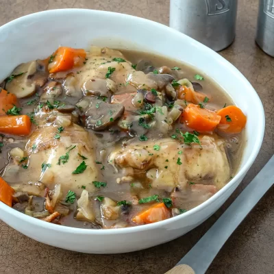 Cooked chicken with vegetables and gravy in a bowl.