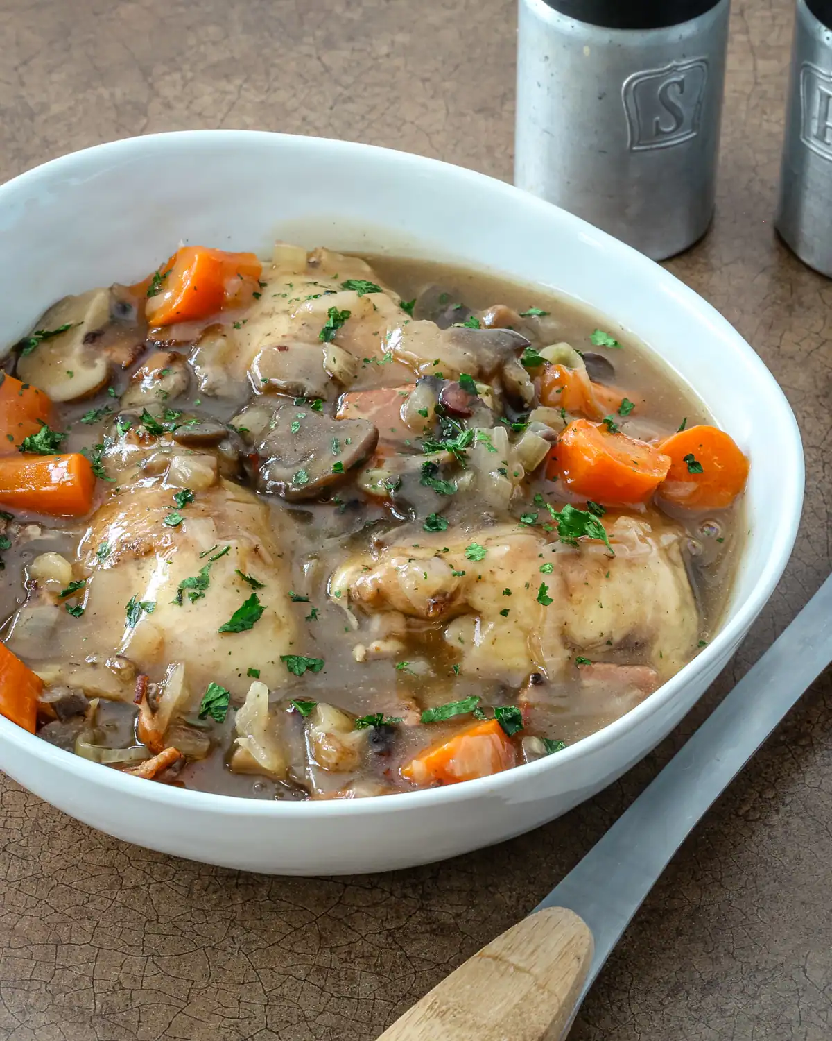 Cooked chicken with vegetables and gravy in a bowl.