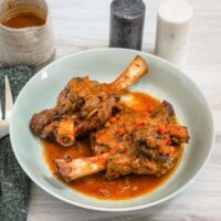 Hearty roasted lamb shanks in rich tomato sauce with vegetables.