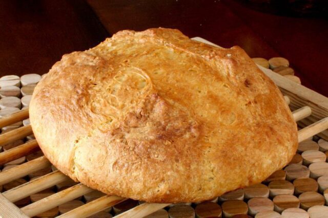 A loaf of Irish soda bread on a wood cooling rack.