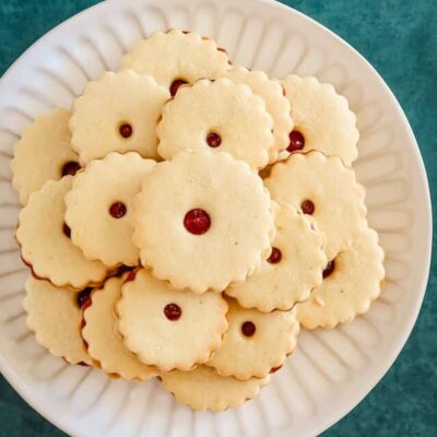 A plate of baked jammie dodgers filled with raspberry jam.