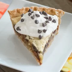 Sweet pie with whipped cream and chocolate chips on top.