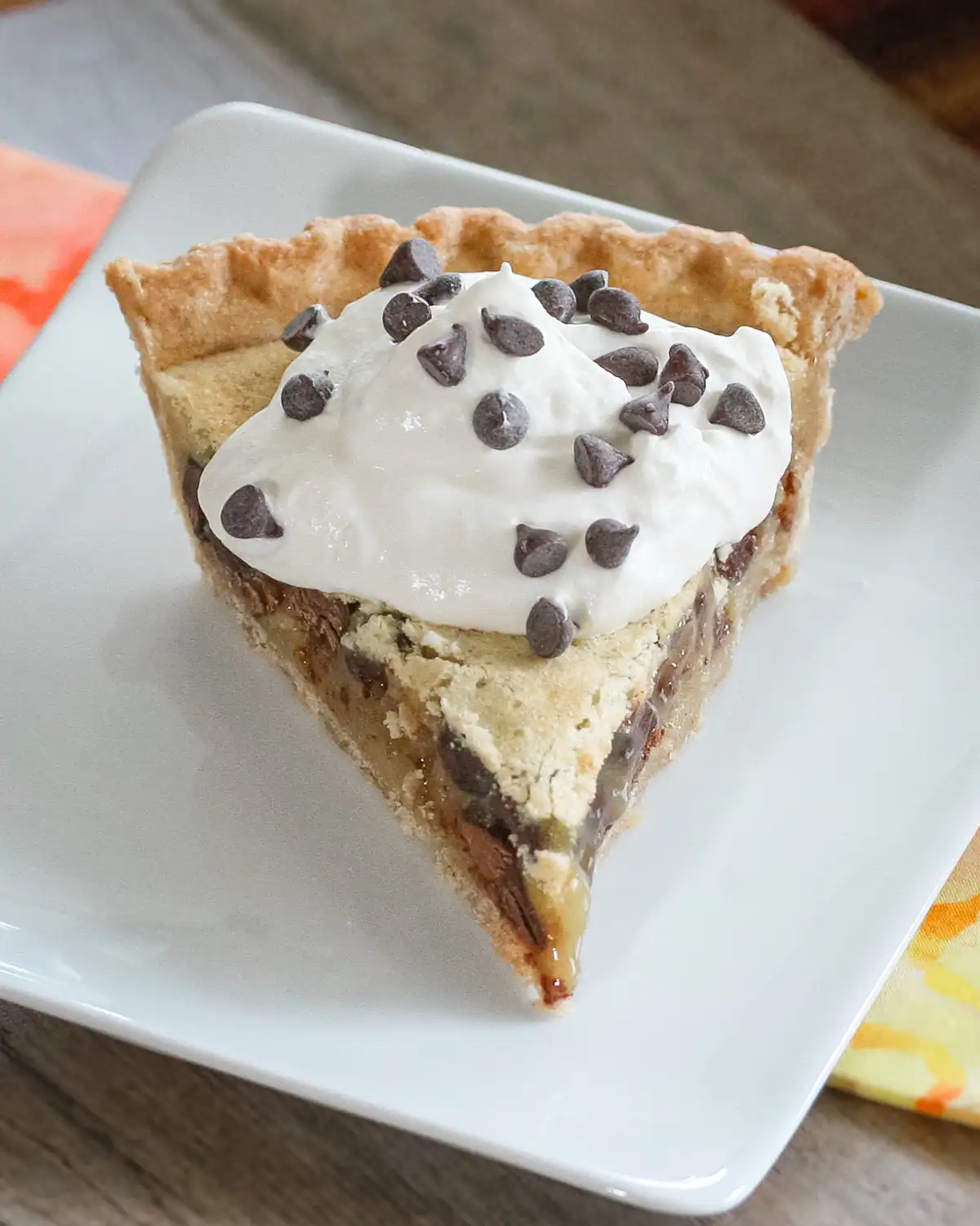 Sweet pie with whipped cream and chocolate chips on top.
