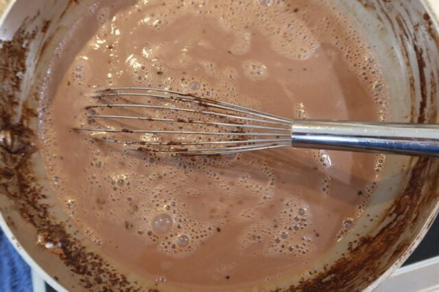 Keto ice cream prep in a saucepan with whisk.