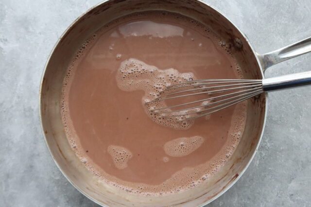 Keto ice cream prep in a saucepan with whisk.