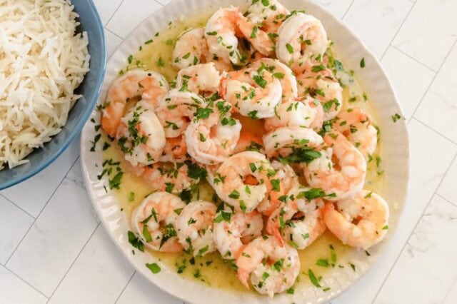 Shrimp in a bowl with rice on the side.
