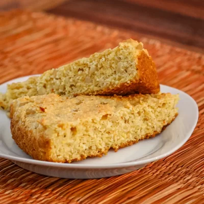 Golden baked cornbread slices on a white plate.