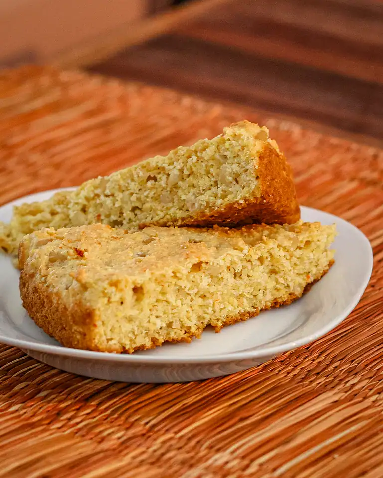 Golden baked cornbread slices on a white plate.