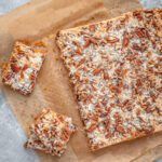 classic magic cookie bars, baked, on parchment paper sliced