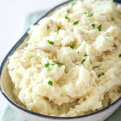 Creamy mashed potatoes with fresh herbs in a bowl.