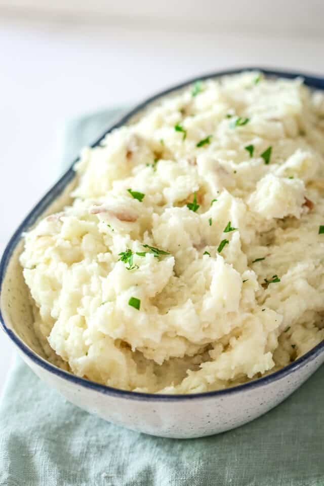Creamy mashed potatoes with fresh herbs in a bowl.