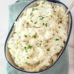 Creamy mashed potatoes with parsley garnish.