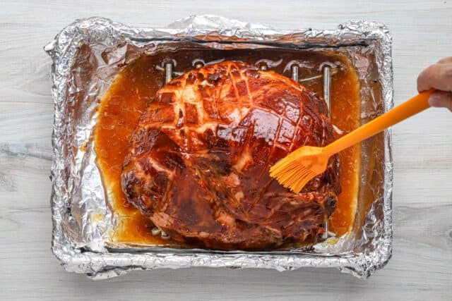 Maple and brown sugar glaze brushed over the ham.