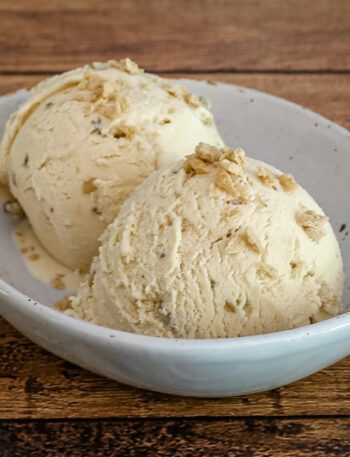 maple walnut ice cream in a bowl with maple flakes garnish