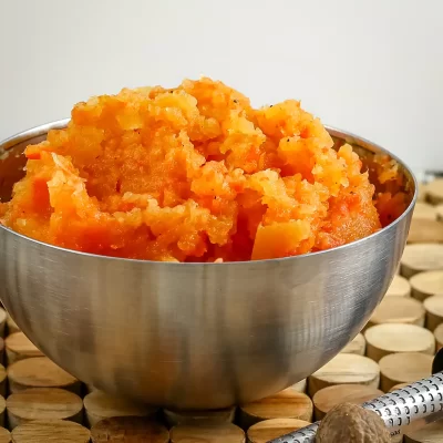 Creamy mashed sweet potatoes served in a metal bowl.