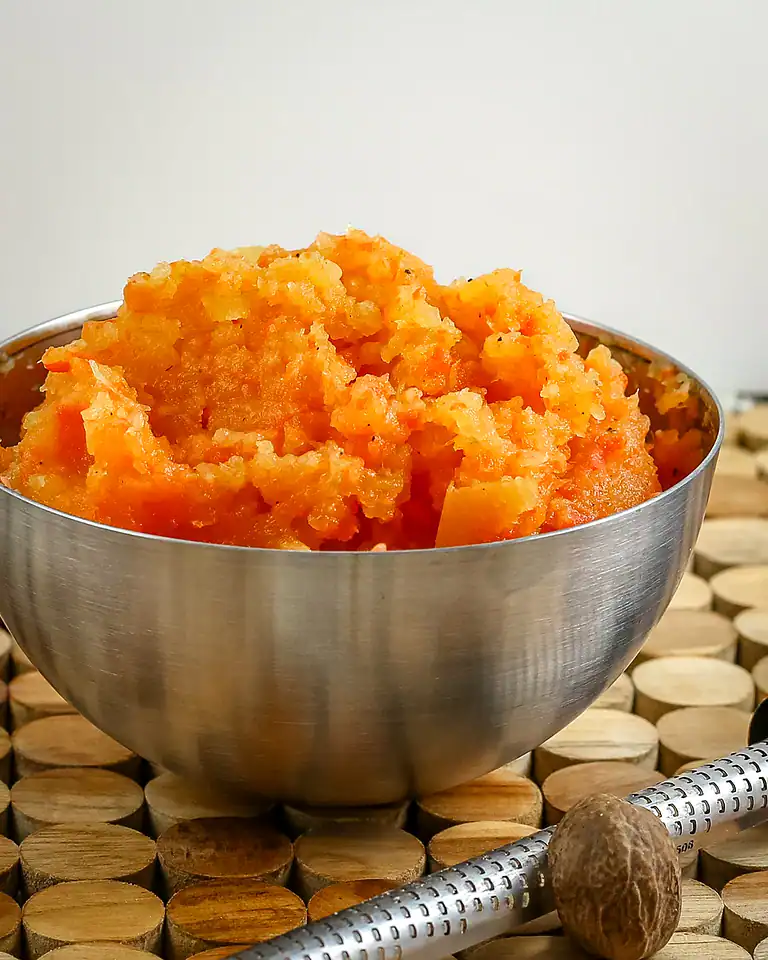 Creamy mashed sweet potatoes served in a metal bowl.