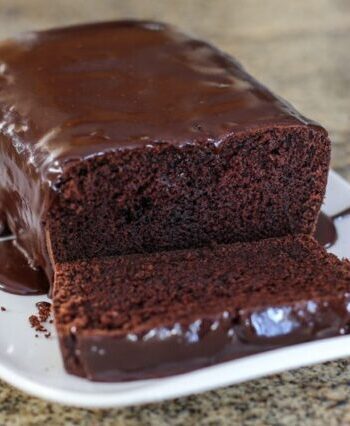 A chocolate loaf cake on a serving tray.