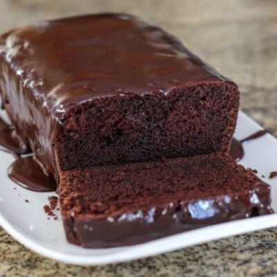A chocolate loaf cake on a serving tray.