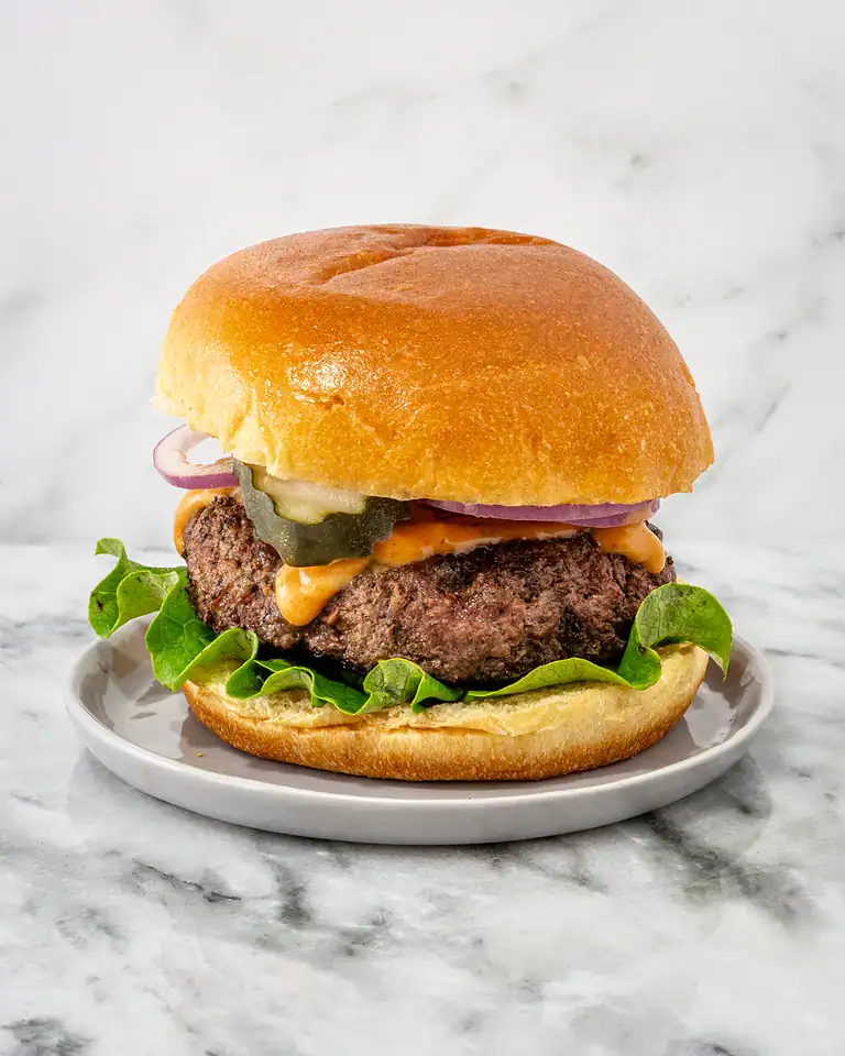 Juicy beef burger with fresh vegetables and melted cheese.
